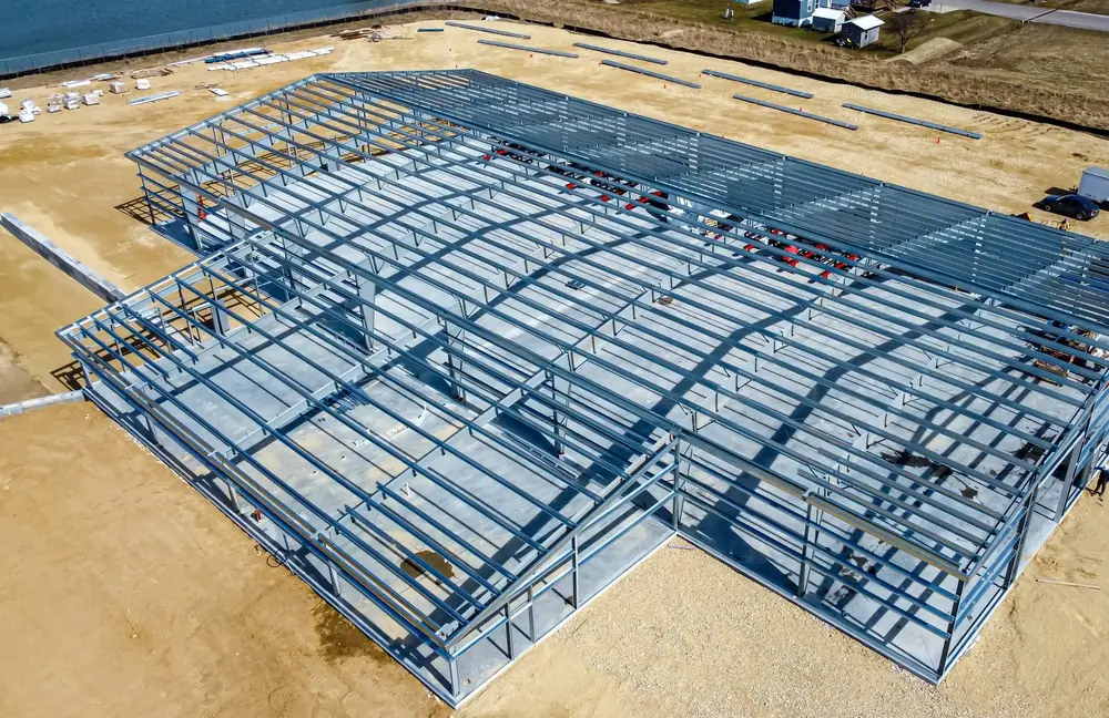 Ossature métallique d’un bâtiment en cours de montage sur son terrain, vue aérienne