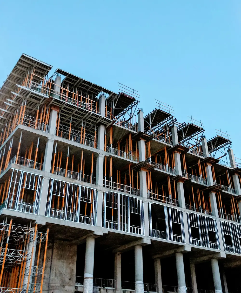 Immeuble d'habitation en chantier, planchers et poteaux en béton armé sous un ciel bleu