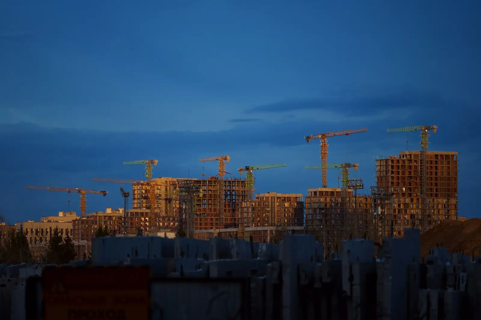 Grues au-dessus d’immeubles en construction, au crépuscule